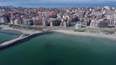 Bulgaristan 'ın kayalık yarımadasında bulunan ve büyük mavi, tuzlu Karadeniz tarafından turlanan küçük ve yoğun nüfuslu Pomorie kasabasına kuş bakışı bir bakış. UHD 4K video gerçek zamanlı