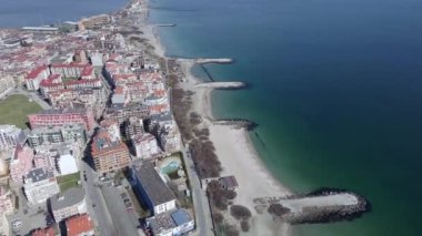 Bulgaristan 'ın kayalık yarımadasında bulunan ve büyük mavi, tuzlu Karadeniz tarafından turlanan küçük ve yoğun nüfuslu Pomorie kasabasına kuş bakışı bir bakış. UHD 4K video gerçek zamanlı
