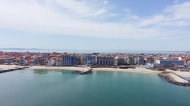 Bulgaristan 'ın kayalık yarımadasında bulunan ve büyük mavi, tuzlu Karadeniz tarafından turlanan küçük ve yoğun nüfuslu Pomorie kasabasına kuş bakışı bir bakış. UHD 4K video gerçek zamanlı