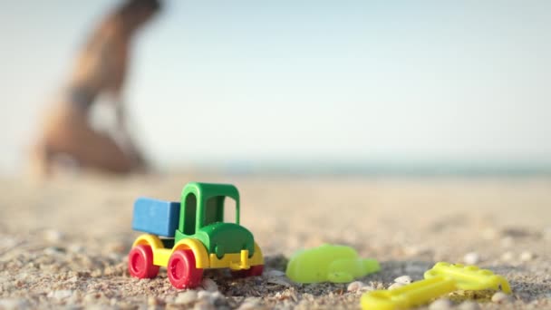 Πολλά Φωτεινά Πολύχρωμα Πλαστικά Παιχνίδια Βρίσκονται Μια Μεγάλη Αμμώδη Παραλία — Αρχείο Βίντεο