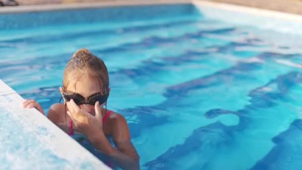 Ein Kleines Mädchen Einem Knallrosa Badeanzug Mit Transparenter Schwarzer Schwimmbrille — Stockvideo