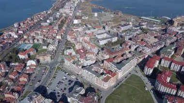 Bulgaristan 'ın kayalık yarımadasında bulunan ve büyük mavi, tuzlu Karadeniz tarafından turlanan küçük ve yoğun nüfuslu Pomorie kasabasına kuş bakışı bir bakış. UHD 4K video gerçek zamanlı