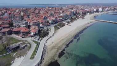 Bulgaristan 'ın kayalık yarımadasında bulunan ve büyük mavi, tuzlu Karadeniz tarafından turlanan küçük ve yoğun nüfuslu Pomorie kasabasına kuş bakışı bir bakış. UHD 4K video gerçek zamanlı