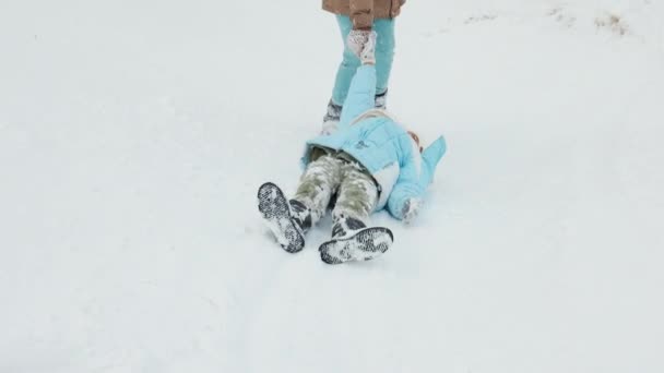 Вид Сзади Двух Счастливых Детей Теплых Пальто Валяющихся Снегу Бегущих — стоковое видео