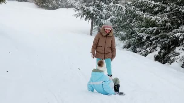 遊び心のある子供たちのバックビューは 雪のスプルースの森で追いかけて実行しています 冬の山の中でアウトドアを楽しんで キャッチを果たしている幸せ かわいい女性の子供たち 冬休みの概念 — ストック動画