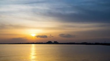 View of magical brilliant bewitching reflection in calm blue quiet Black Sea, against background of sea horizon with cloudy multi-colored sky and bright evening sunset. 4K UHD timelapse video