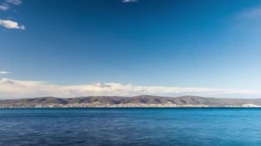 View of magical brilliant bewitching reflection in calm blue quiet Black Sea, against background of sea horizon with cloudy multi-colored sky and bright evening sunset. 4K UHD timelapse video