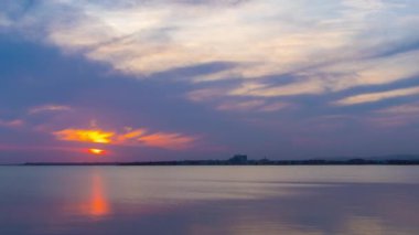 View of magical brilliant bewitching reflection in calm blue quiet Black Sea, against background of sea horizon with cloudy multi-colored sky and bright evening sunset. 4K UHD timelapse video