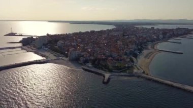 Bulgaristan 'ın kayalık yarımadasında bulunan ve büyük mavi, tuzlu Karadeniz tarafından turlanan küçük ve yoğun nüfuslu Pomorie kasabasına kuş bakışı bir bakış. UHD 4K video gerçek zamanlı