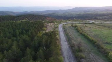 Birds eye view of spring blooming green meadows and wooded hilly slopes of the Balkan Mountains, under the light of a bright cloudy warm day in the country of Bulgaria. UHD 4K video realtime