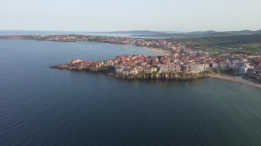 Birds eye view of the modern historic small town of Sozopol with a variety of cozy seaside houses and small sea spring boats, near the calm deep rippled Black Sea. UHD 4K video realtime