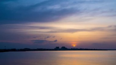 View of magical brilliant bewitching reflection in calm blue quiet Black Sea, against background of sea horizon with cloudy multi-colored sky and bright evening sunset. 4K UHD timelapse video