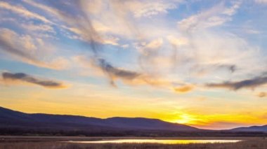 Extraordinary fantastic view of beautiful blue sunny sunset sky with mighty bright clouds over hilly Balkan Mountains, and small bay of Black Sea near wild grassy beach. 4K UHD timelapse video