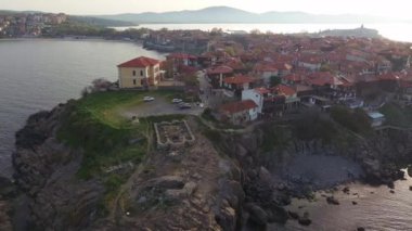 Birds eye view of the modern historic small town of Sozopol with a variety of cozy seaside houses and small sea spring boats, near the calm deep rippled Black Sea. UHD 4K video realtime