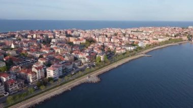 Bulgaristan 'ın kayalık yarımadasında bulunan ve büyük mavi, tuzlu Karadeniz tarafından turlanan küçük ve yoğun nüfuslu Pomorie kasabasına kuş bakışı bir bakış. UHD 4K video gerçek zamanlı
