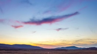 Extraordinary fantastic view of beautiful blue sunny sunset sky with mighty bright clouds over hilly Balkan Mountains, and small bay of Black Sea near wild grassy beach. 4K UHD timelapse video