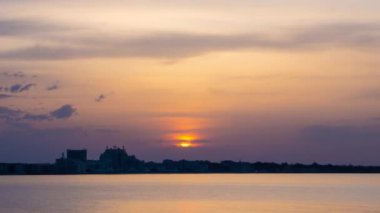 View of magical brilliant bewitching reflection in calm blue quiet Black Sea, against background of sea horizon with cloudy multi-colored sky and bright evening sunset. 4K UHD timelapse video