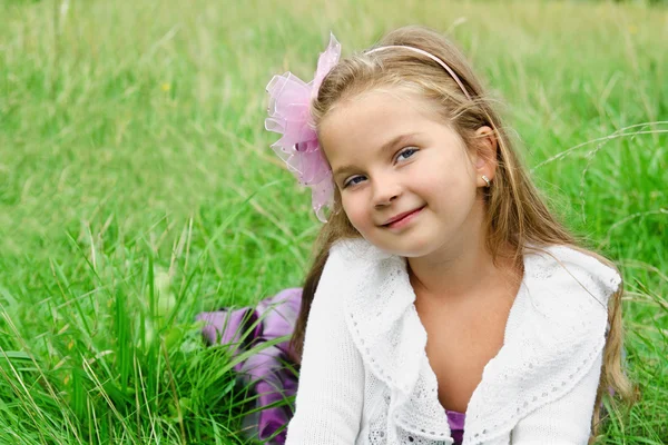 Retrato de una linda niña acostada en un prado — Foto de Stock