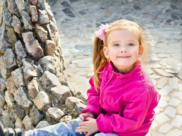 Outdoor portrait of cute sitting little girl — Stock Photo, Image