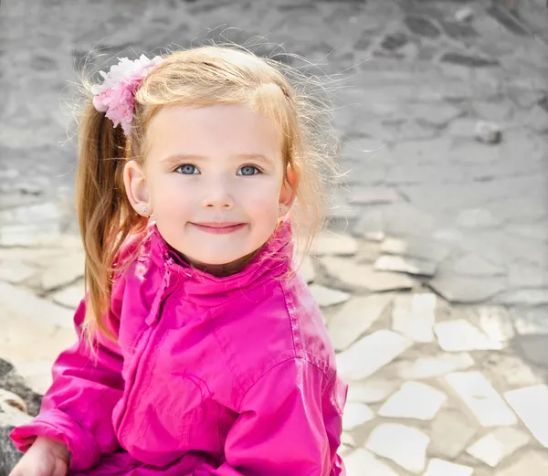 Outdoor portrait of cute sitting little girl — Stock Photo, Image