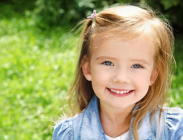 Utomhus porträtt av leende liten flicka Stockbild