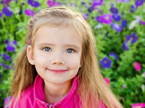 Portrait extérieur de mignonne petite fille près des fleurs — Photo