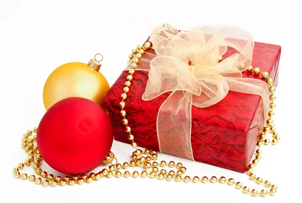 Bolas de Navidad de oro rojo y caja de regalo en un blanco — Foto de Stock