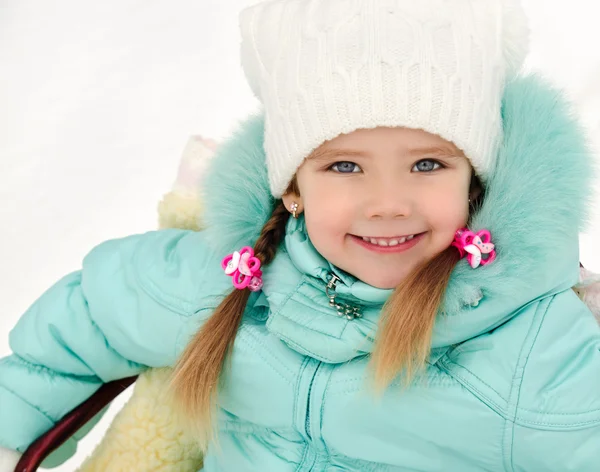 Kış günü onun kızak üzerinde oturan küçük kız — Stok fotoğraf