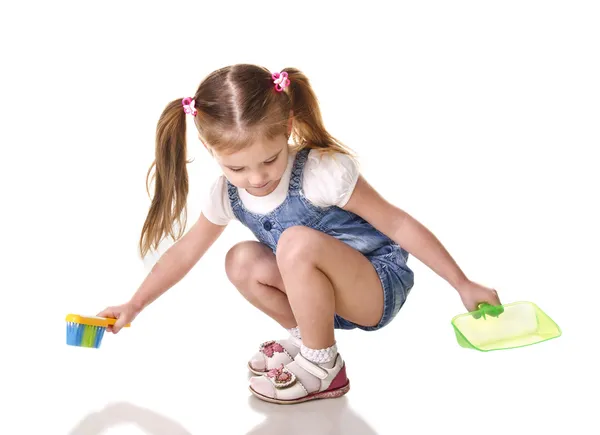 Niedliche kleine Mädchen fegt einen Fußboden isoliert — Stockfoto