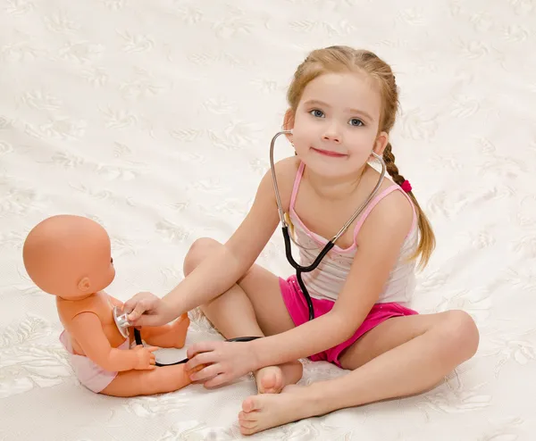 Маленькая девочка играет с куклой в больнице — стоковое фото