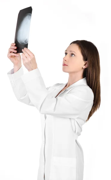 Jonge vrouwelijke arts kijken naar de x-ray foto van hoofd isoleren — Stockfoto