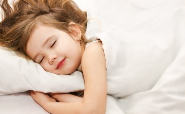 Little girl sleep in the bed close-up clipart