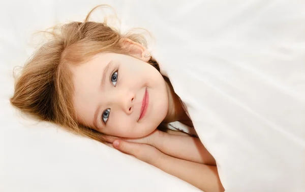 Маленькая девочка проснулась в своей постели — стоковое фото
