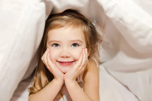 Smiling little girl in the bed — Stock Photo, Image
