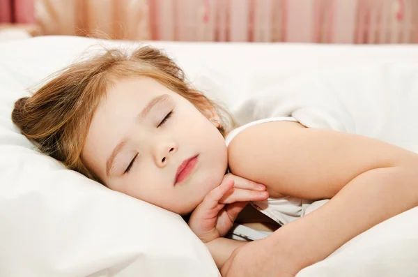 Liten flicka sova i sängen — Stockfoto