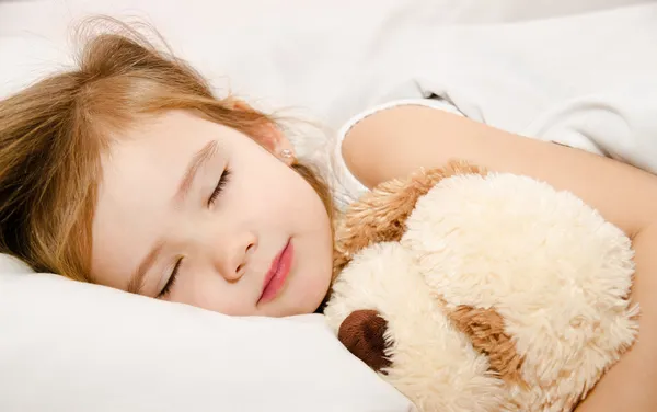 Schattig meisje slaapt in het bed — Stockfoto