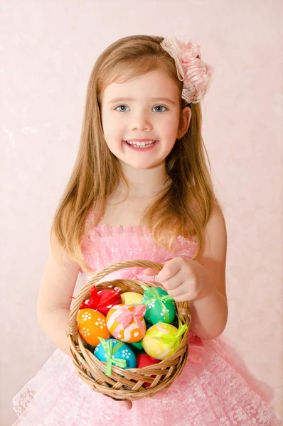 Little girl with basket full of colorful easter eggs — Stock Photo, Image