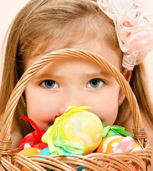 Liten flicka med korg full av färgglada påskägg — Stockfoto