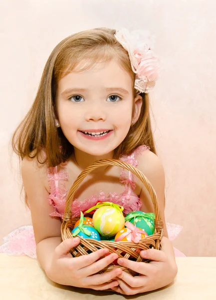 Niña con cesta llena de coloridos huevos de Pascua — Foto de Stock