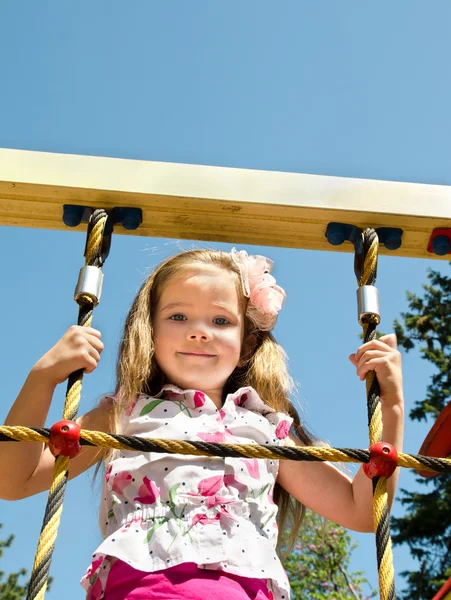 Cute little girl is climbing up on ladder in playground — Stock Photo, Image