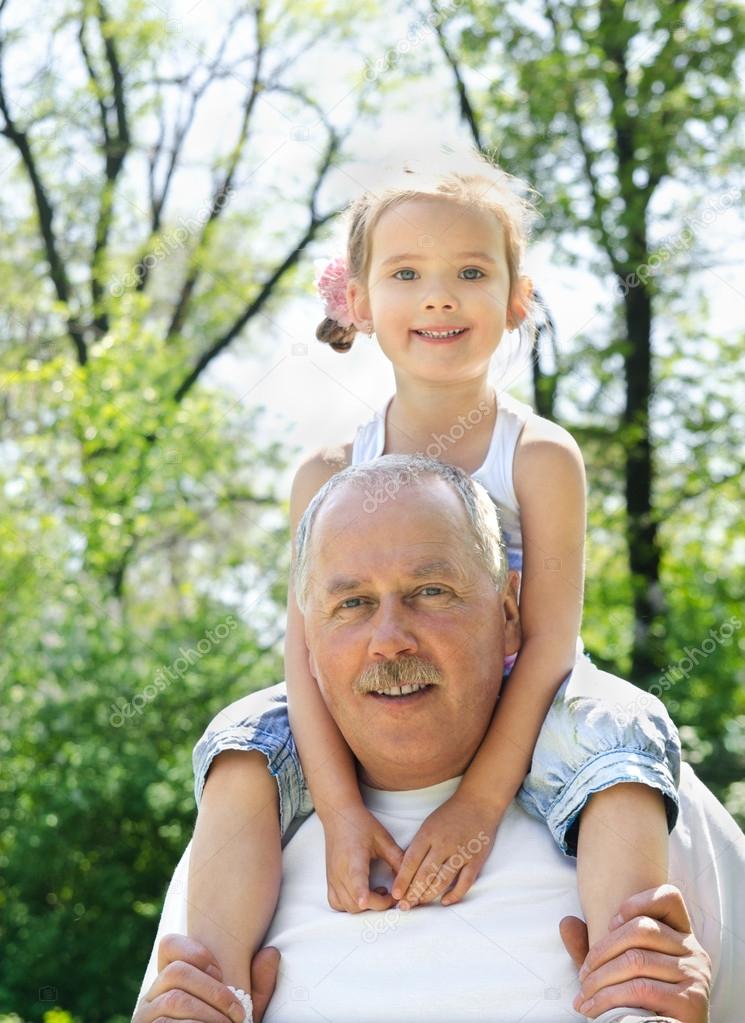 Outdoor portrait of granddaughter and grandfather
