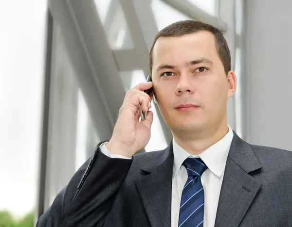 Retrato do jovem empresário telefonando por telefone — Fotografia de Stock