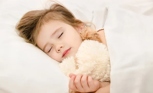 Aranyos kislány alszik az ágyban — Stock Fotó