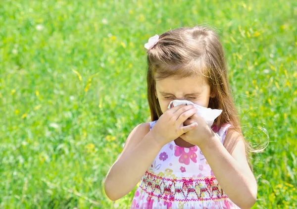 小さな女の子が彼女の鼻を吹いています。 — ストック写真