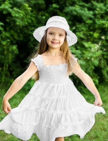 Portret van schattige lachende meisje in witte jurk en hoed — Stockfoto