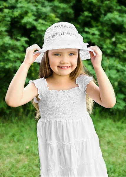 Retrato de adorável sorridente menina em vestido branco e chapéu — Fotografia de Stock
