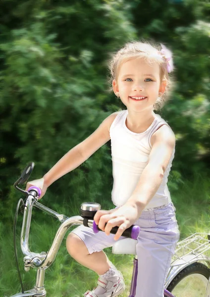 Ler söt liten flicka med hennes cykel — Stockfoto