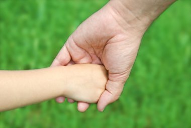 çocuk babasının elini tutar