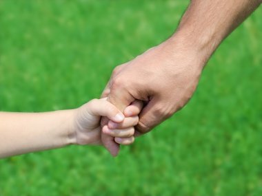 çocuk babasının elini tutar