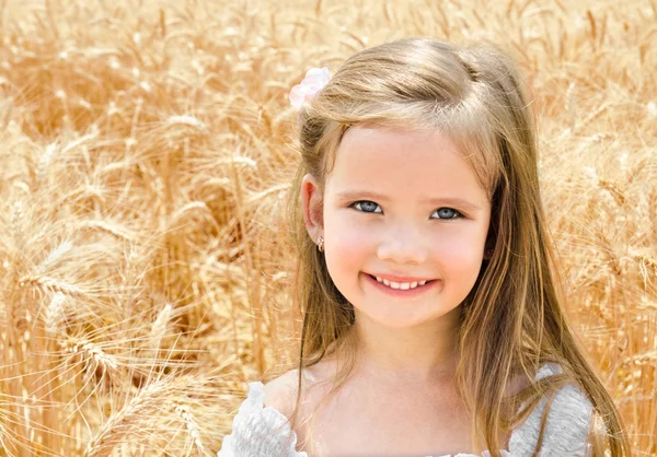 可爱微笑在麦田中的小女孩 — 图库照片